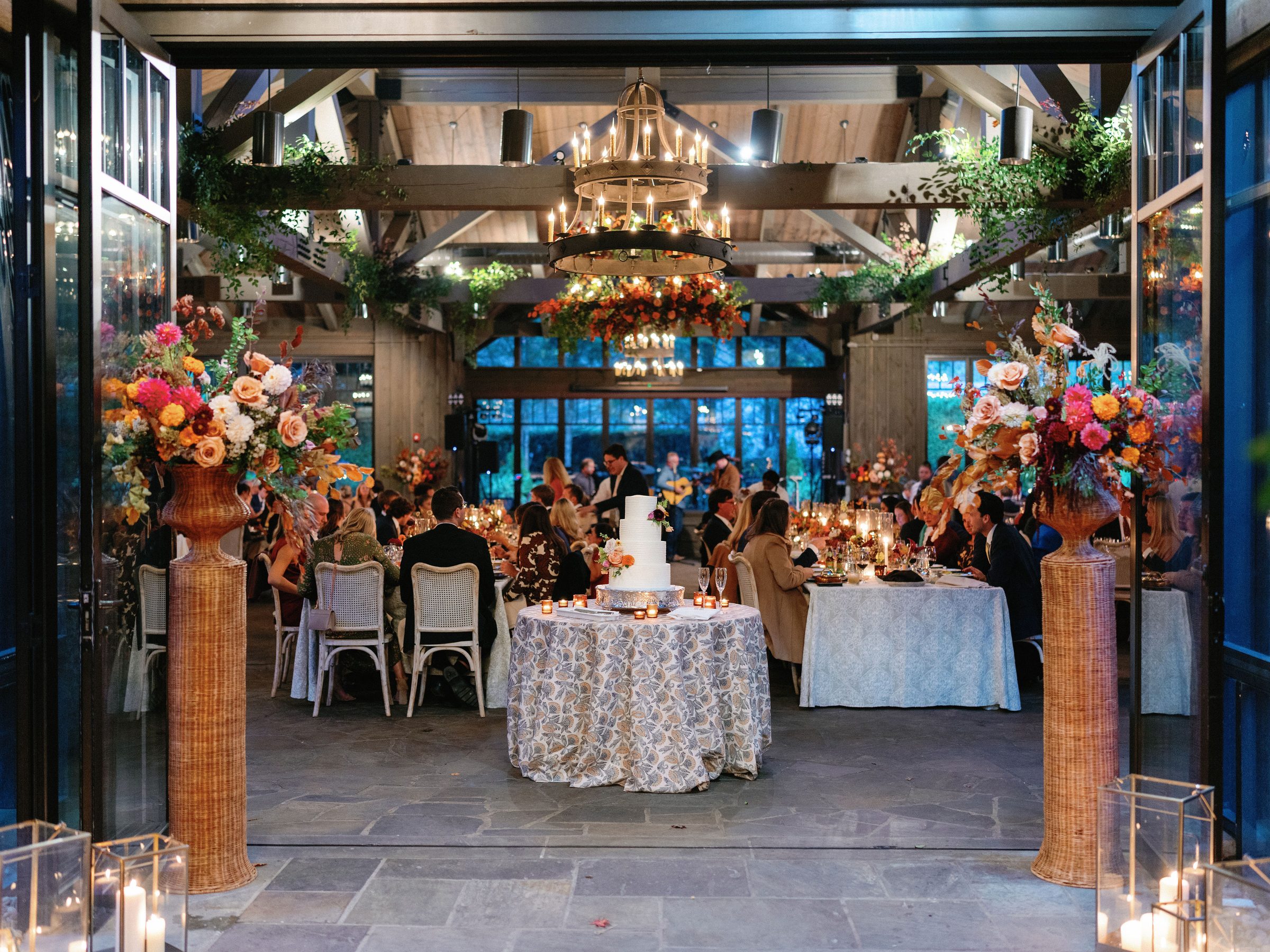 Bespoke wedding cake framed by autumn florals at a candlelit reception — Mrs. Sugar Booger, Highlands NC